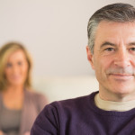 Smiling man with his wife in the background